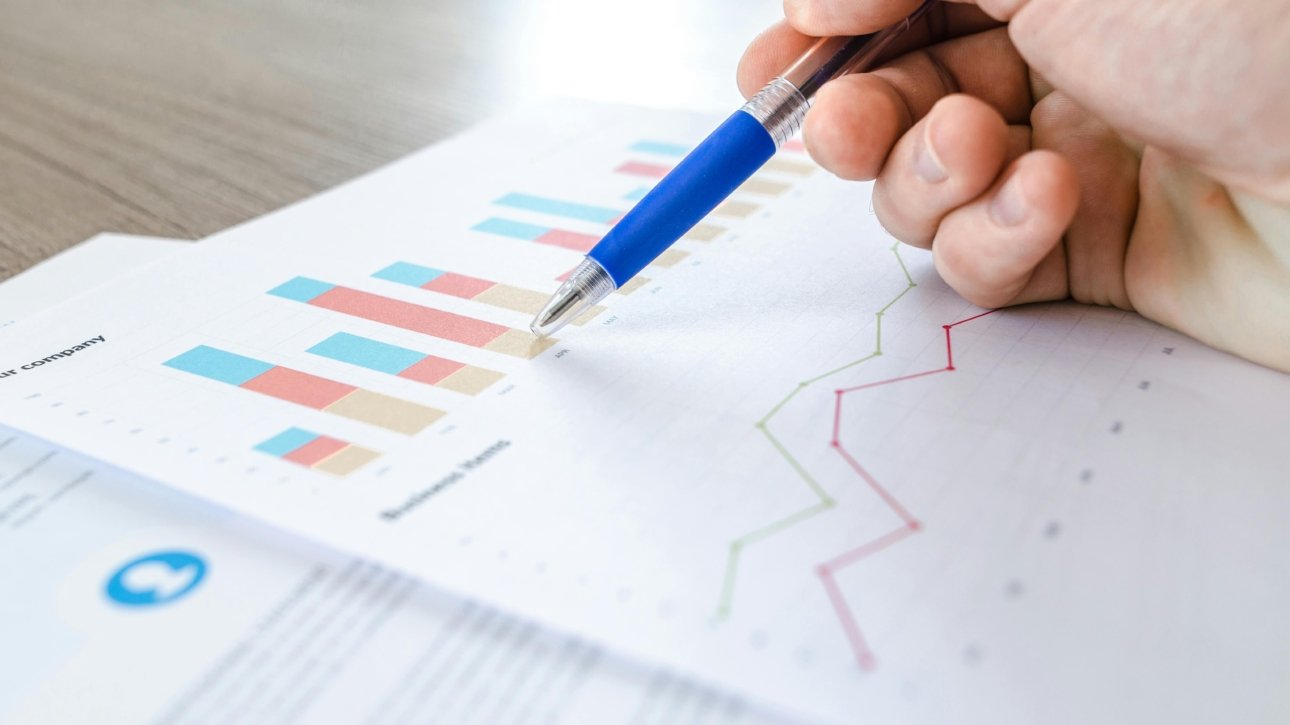 picture of a person sketching on a piece of paper that has graphs and diagrams