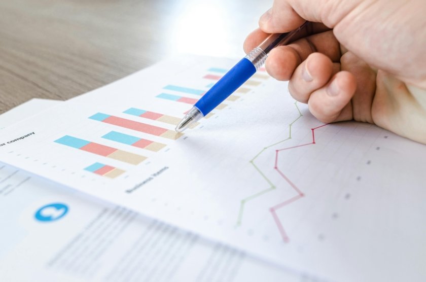 picture of a person sketching on a piece of paper that has graphs and diagrams