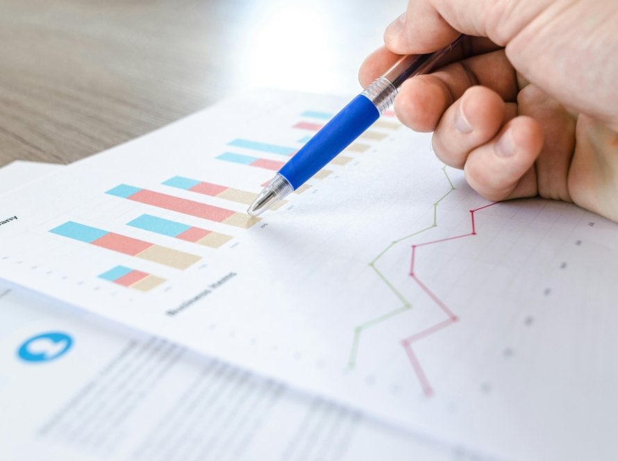 picture of a person sketching on a piece of paper that has graphs and diagrams